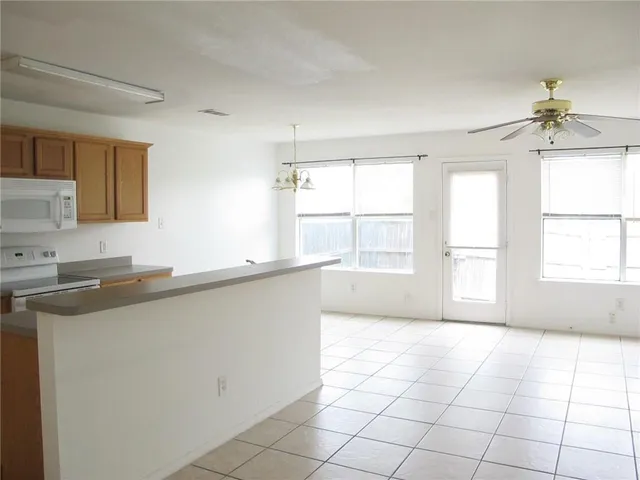 a open kitchen with cabinets a window and a sink