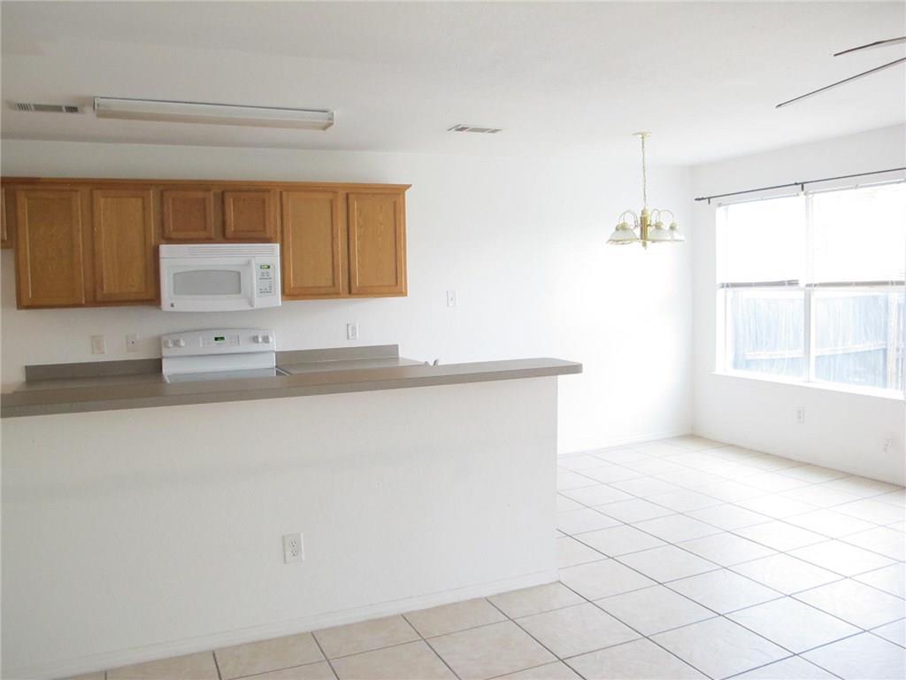 4503 Fortuna Street Fort Worth, TX 76119 - Photo 9 of 26 a kitchen with granite countertop white cabinets and window