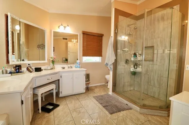 a bathroom with a double vanity sink toilet and shower