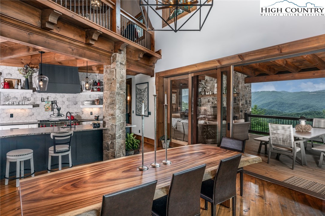 550 Pepperroot Road Boone, NC 28607 - Photo 19 of 50 a kitchen with stainless steel appliances kitchen island granite countertop a table chairs in it and wooden floors