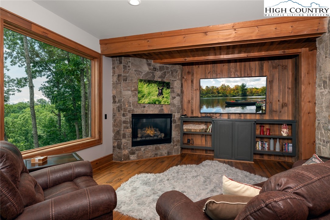 550 Pepperroot Road Boone, NC 28607 - Photo 42 of 50 a living room with furniture a flat screen tv and a floor to ceiling window