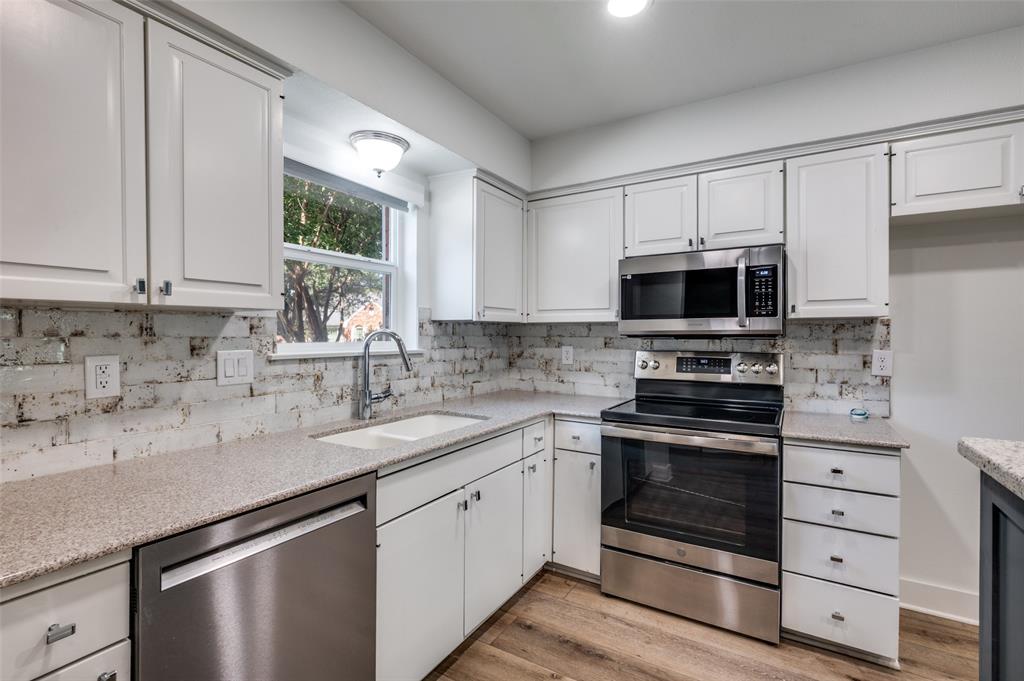 1257 Roaring Springs Road Fort Worth, TX 76114 - Photo 7 of 11 a kitchen with white cabinets stainless steel appliances and sink