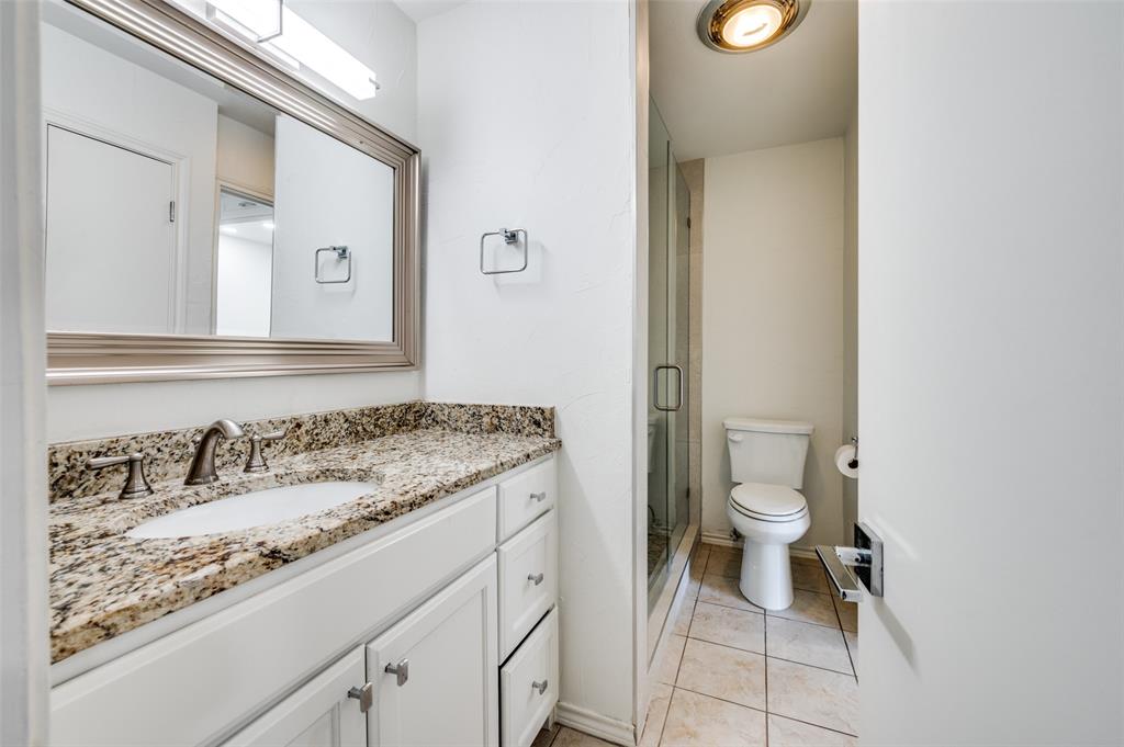 1257 Roaring Springs Road Fort Worth, TX 76114 - Photo 8 of 11 a bathroom with a granite countertop sink a toilet and a mirror