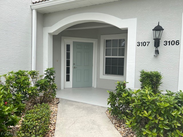 9667 Hemingway Lane, Unit 3107 Fort Myers, FL 33913 - Photo 2 of 23 front view of a house with potted plants