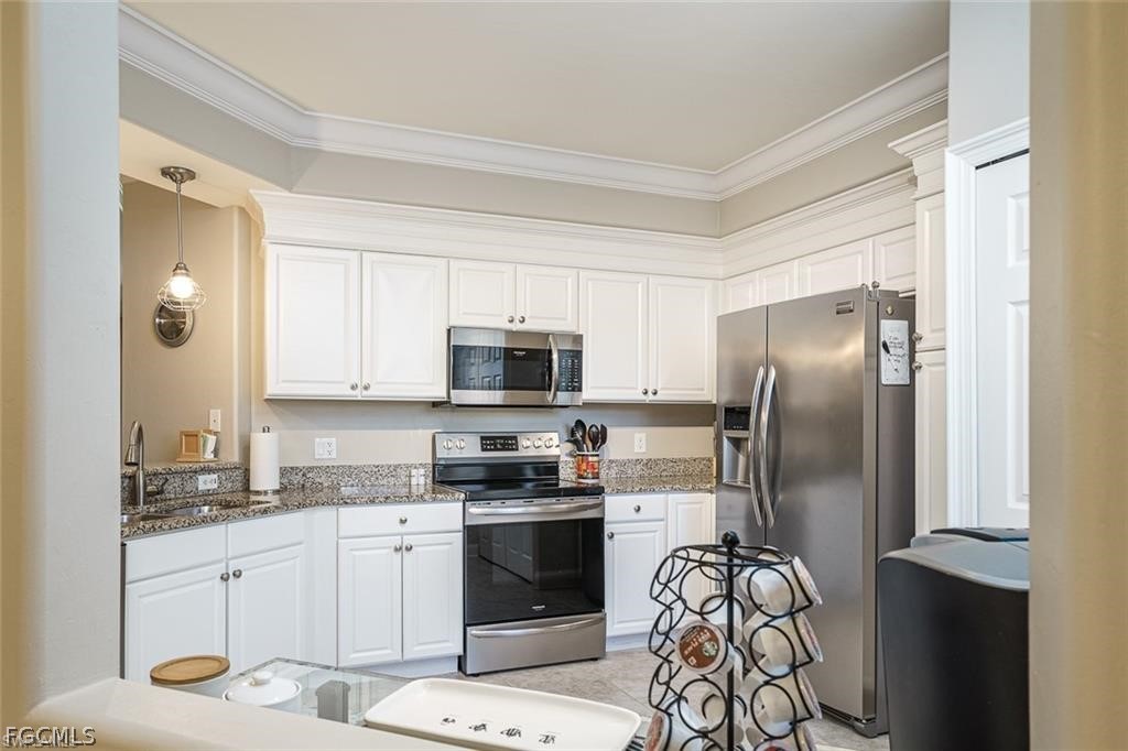 9667 Hemingway Lane, Unit 3107 Fort Myers, FL 33913 - Photo 7 of 23 a kitchen with stainless steel appliances a refrigerator sink and cabinets