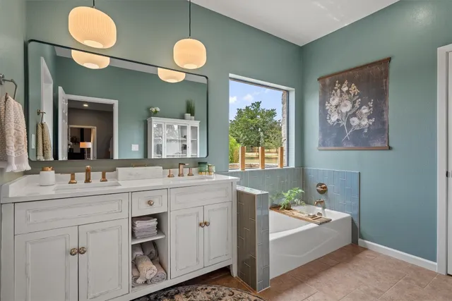 a spacious bathroom with a double vanity sink a mirror and a shower