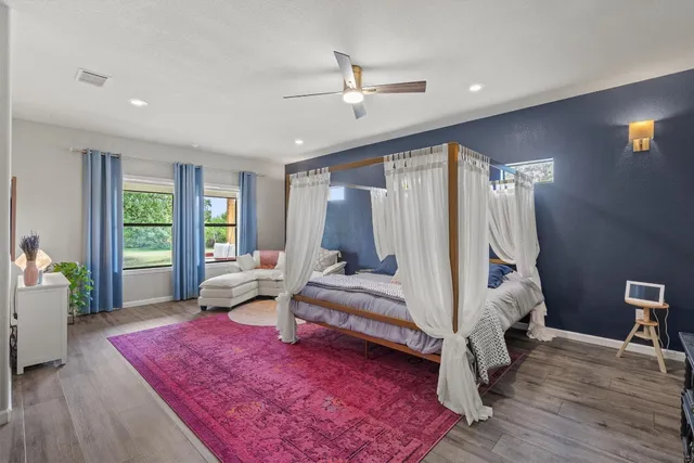 a bedroom with a bed wooden floor and window