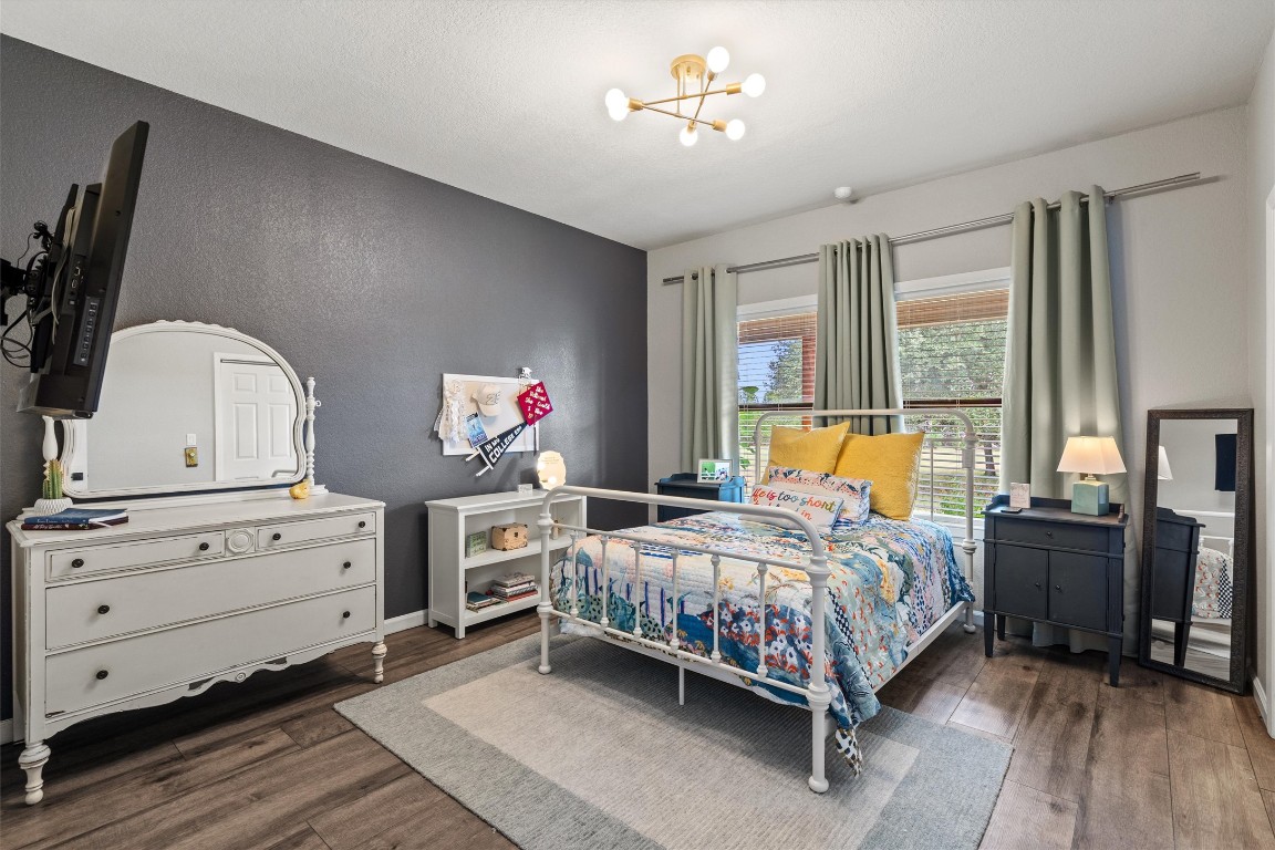 323 Patricia Road Georgetown, TX 78628 - Photo 16 of 40 a bedroom with a bed wooden floor and window