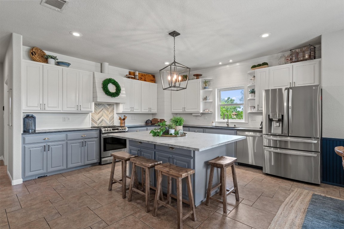 323 Patricia Road Georgetown, TX 78628 - Photo 5 of 40 a kitchen with a refrigerator a stove a sink and chairs