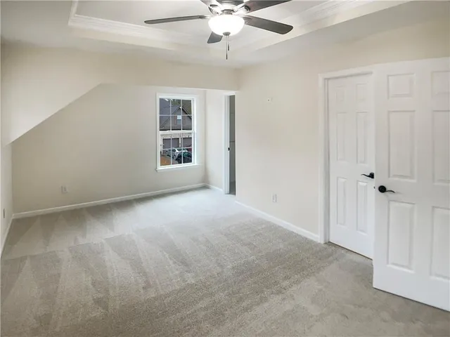 an empty room with windows and ceiling fan