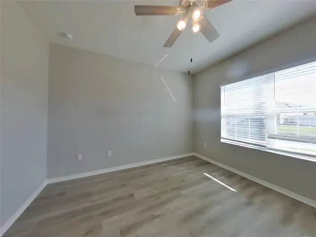 an empty room with a window and a fan