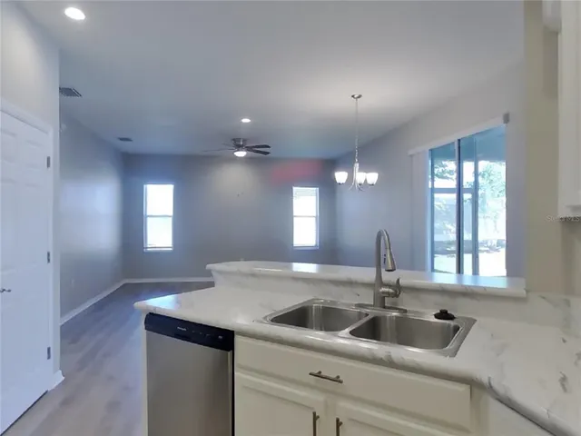 a kitchen with a sink and chandelier