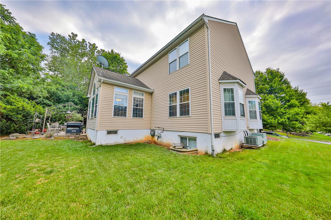 138 Clover Hollow Road Easton, PA 18045 - Photo 77 of 95 A well-maintained side exterior showcases ample yard space, mature landscaping, and bay window details.