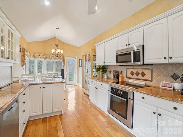 a large kitchen with stainless steel appliances granite countertop a stove and a sink