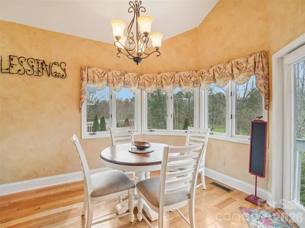a view of a dining room with furniture wooden floor and a chandelier