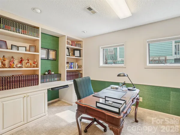 a living room with furniture a piano and a bookshelf