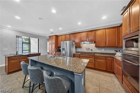 a kitchen with granite countertop sink table and chairs