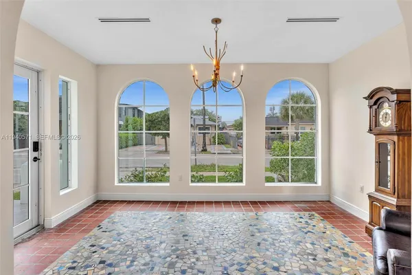 a view of an empty room with fireplace stairs and windows