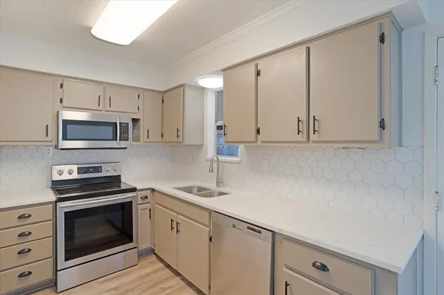a kitchen with white cabinets stainless steel appliances and sink