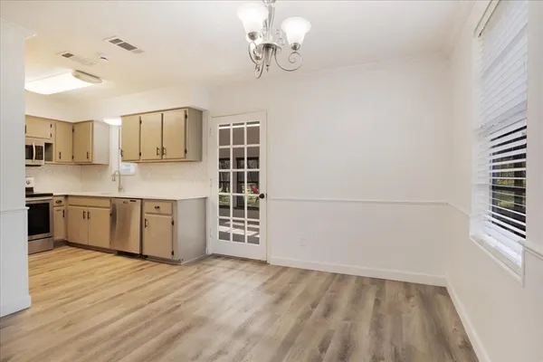 a kitchen with stainless steel appliances a sink cabinets and wooden floor