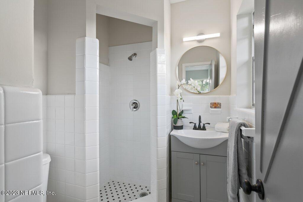 6404 Wesleyan Road Jacksonville, FL 32217 - Photo 21 of 45 a bathroom with a sink a mirror and shower