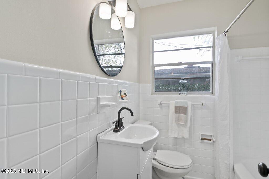 6404 Wesleyan Road Jacksonville, FL 32217 - Photo 28 of 45 a bathroom with a toilet a sink and mirror