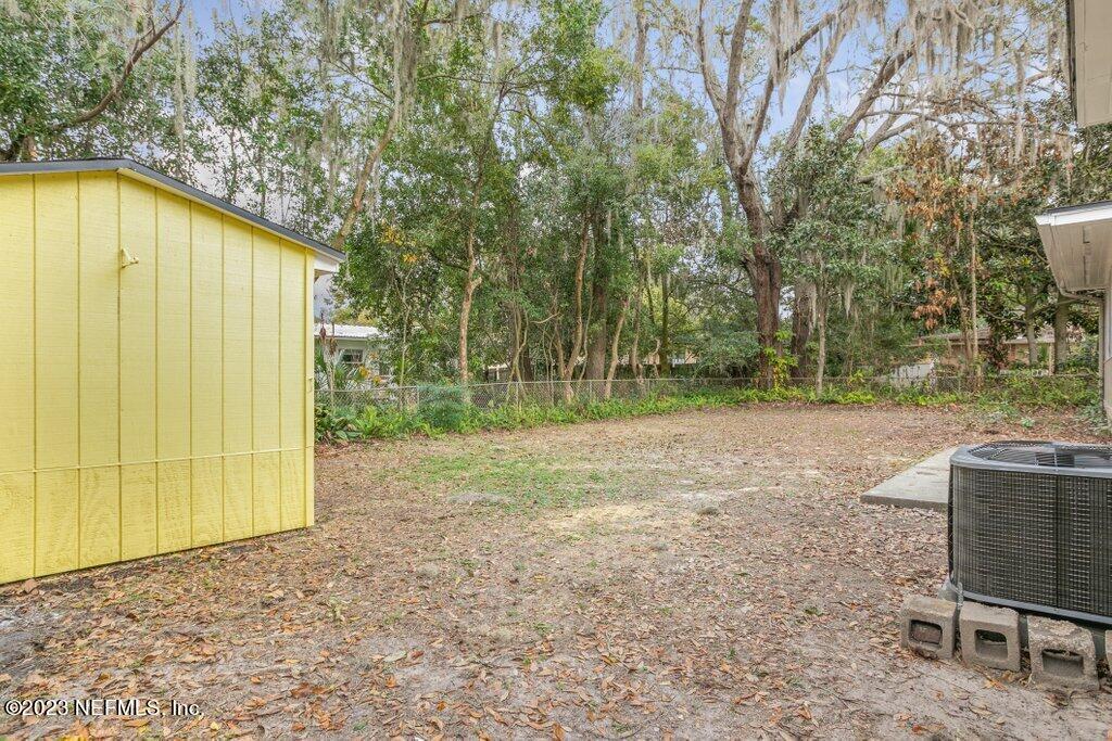 6404 Wesleyan Road Jacksonville, FL 32217 - Photo 38 of 45 a backyard of a house with large trees and a wooden fence