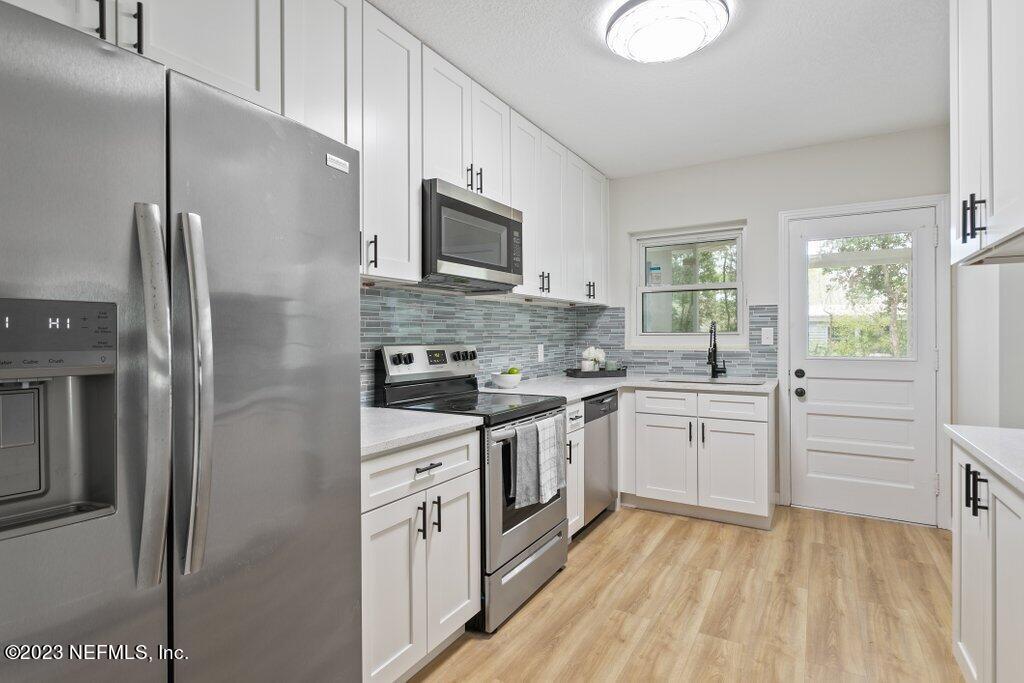 6404 Wesleyan Road Jacksonville, FL 32217 - Photo 8 of 45 a kitchen with white cabinets and stainless steel appliances