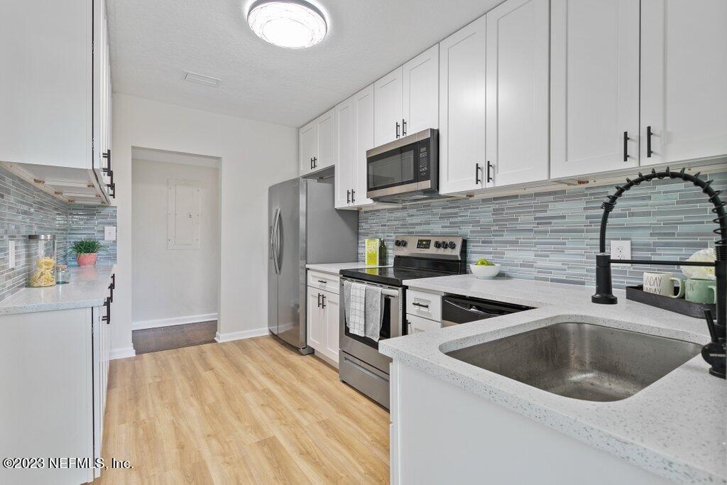 6404 Wesleyan Road Jacksonville, FL 32217 - Photo 9 of 45 a kitchen with stainless steel appliances granite countertop a sink a stove and a refrigerator with cabinets