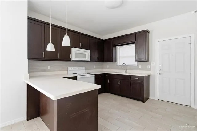 a kitchen with a sink cabinets and wooden floor