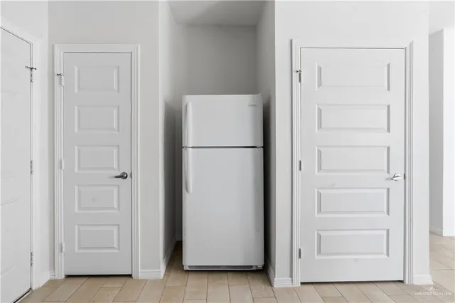 a view of kitchen with refrigerator and cabinet