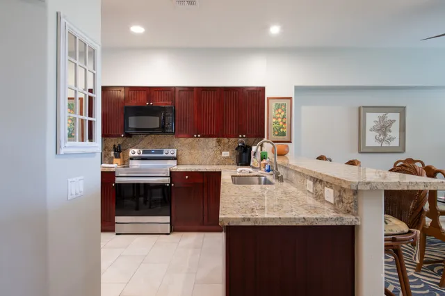 a kitchen with stainless steel appliances granite countertop a stove refrigerator and cabinets