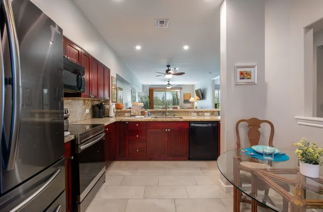 a kitchen with stainless steel appliances granite countertop a refrigerator and a stove top oven