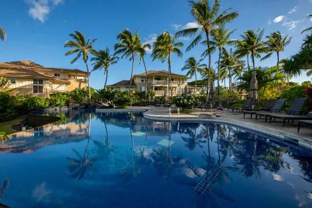 a front view of a house with a yard and potted plants