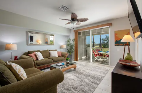 a living room with furniture a ceiling fan and a window