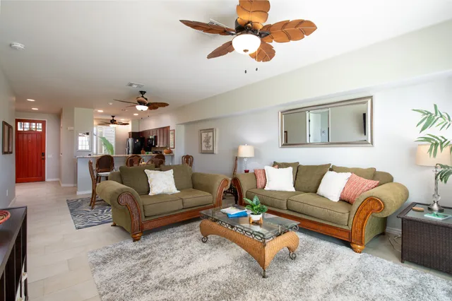 a living room with furniture ceiling fan and a rug