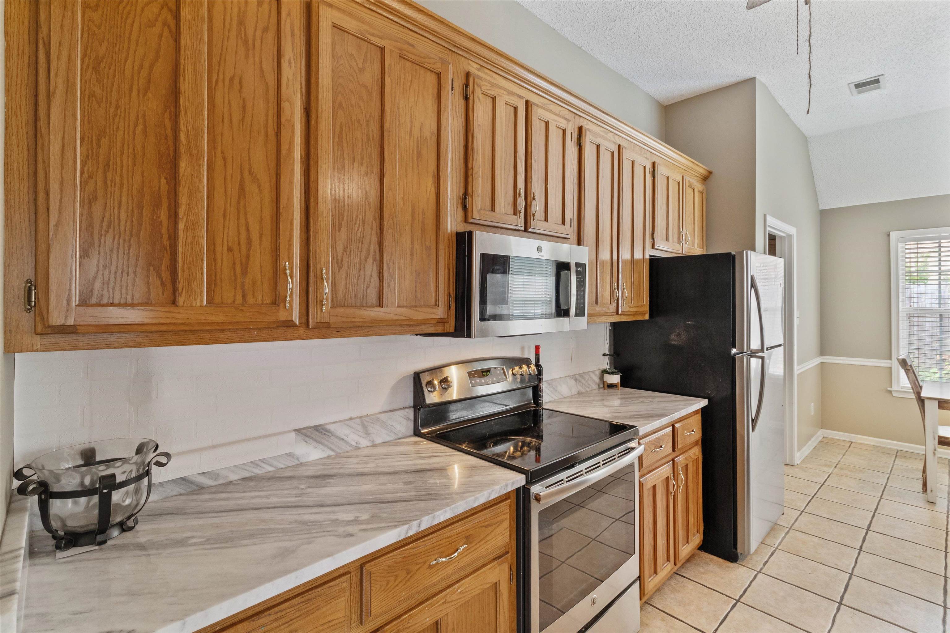 6712 Booth Forrest Drive Bartlett, TN 38135 - Photo 11 of 27 a kitchen with stainless steel appliances granite countertop a refrigerator a stove a sink and dishwasher