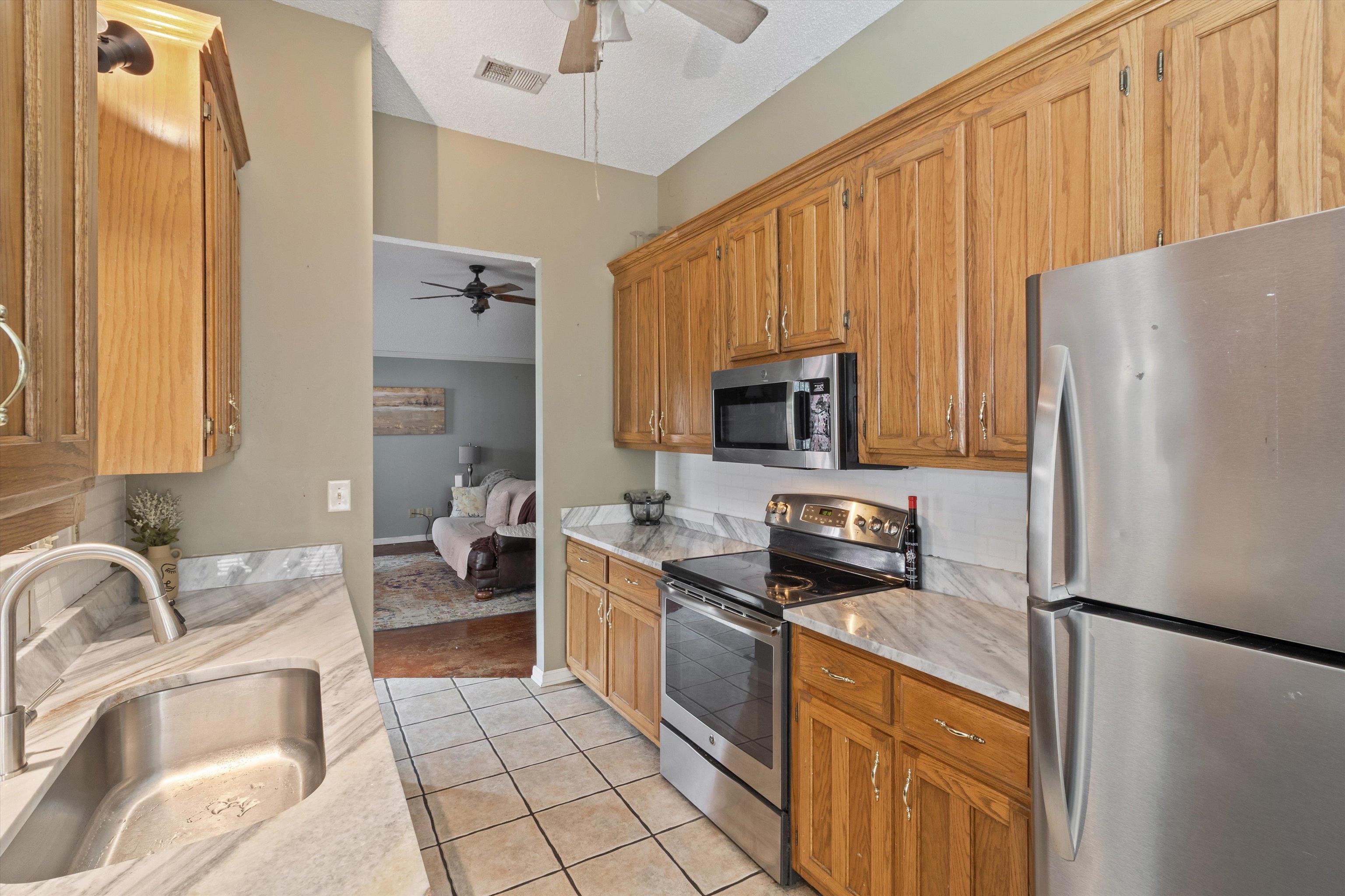6712 Booth Forrest Drive Bartlett, TN 38135 - Photo 13 of 27 a kitchen with stainless steel appliances granite countertop a refrigerator stove microwave and sink