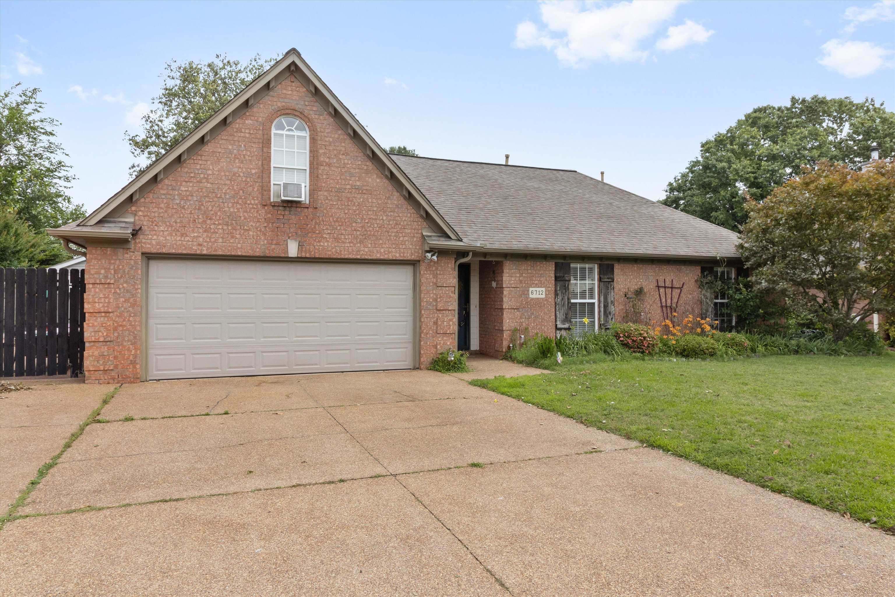 6712 Booth Forrest Drive Bartlett, TN 38135 - Photo 2 of 27 a front view of a house with a yard and garage