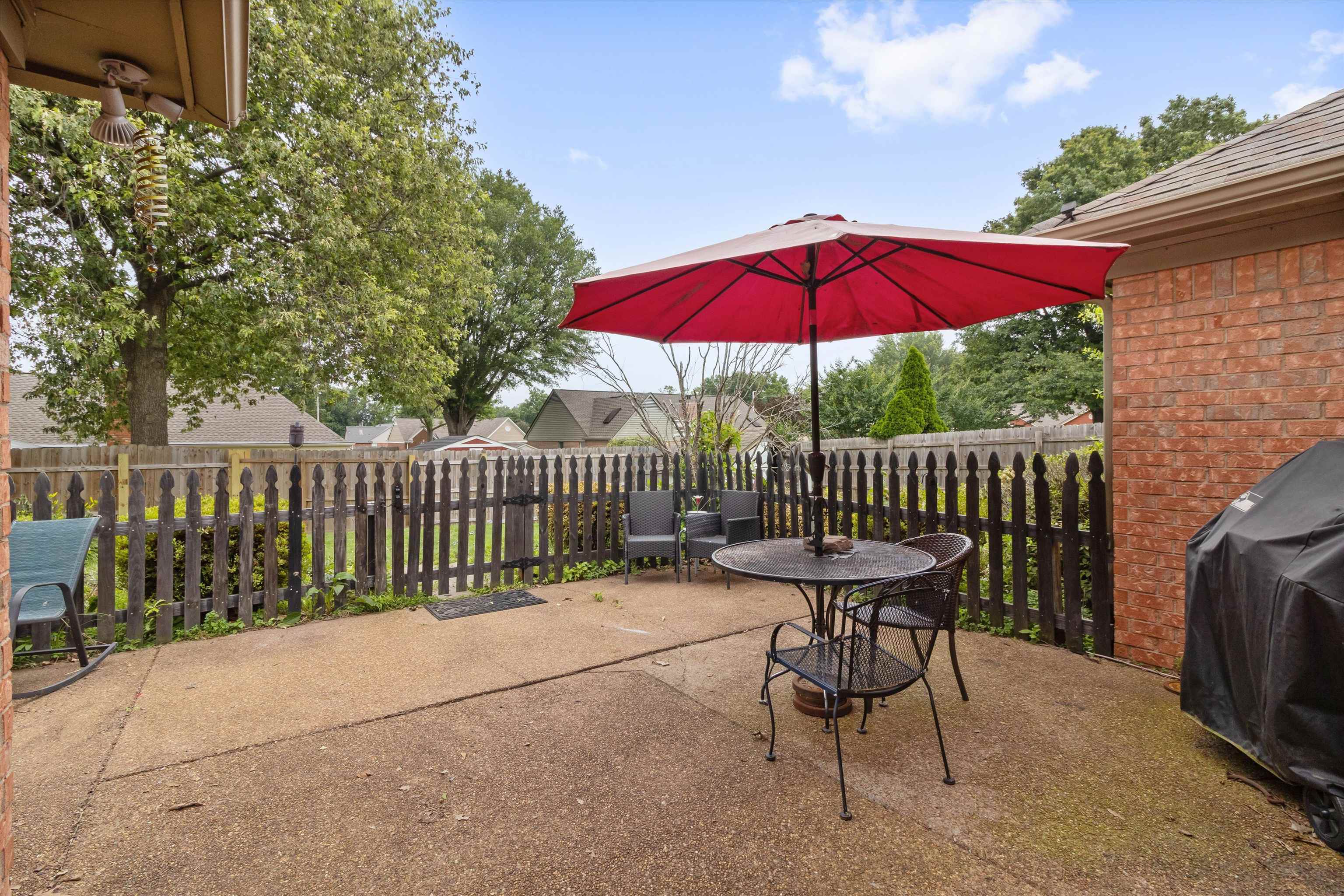 6712 Booth Forrest Drive Bartlett, TN 38135 - Photo 25 of 27 a view of a deck with a table and chairs under an umbrella