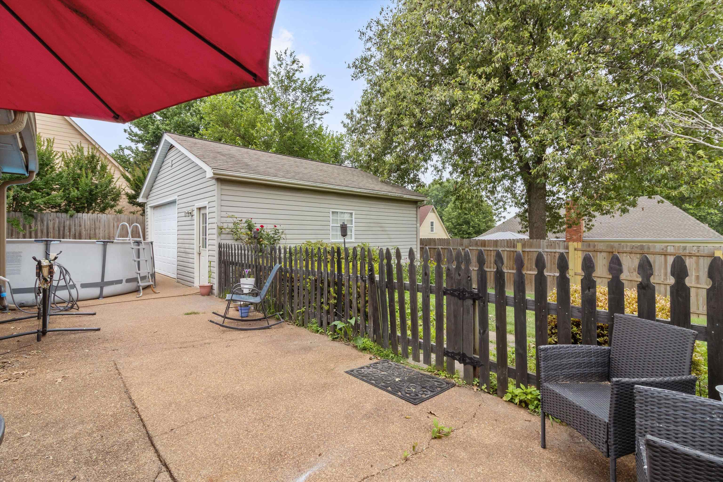 6712 Booth Forrest Drive Bartlett, TN 38135 - Photo 26 of 27 a view of a patio with a table and chairs under an umbrella