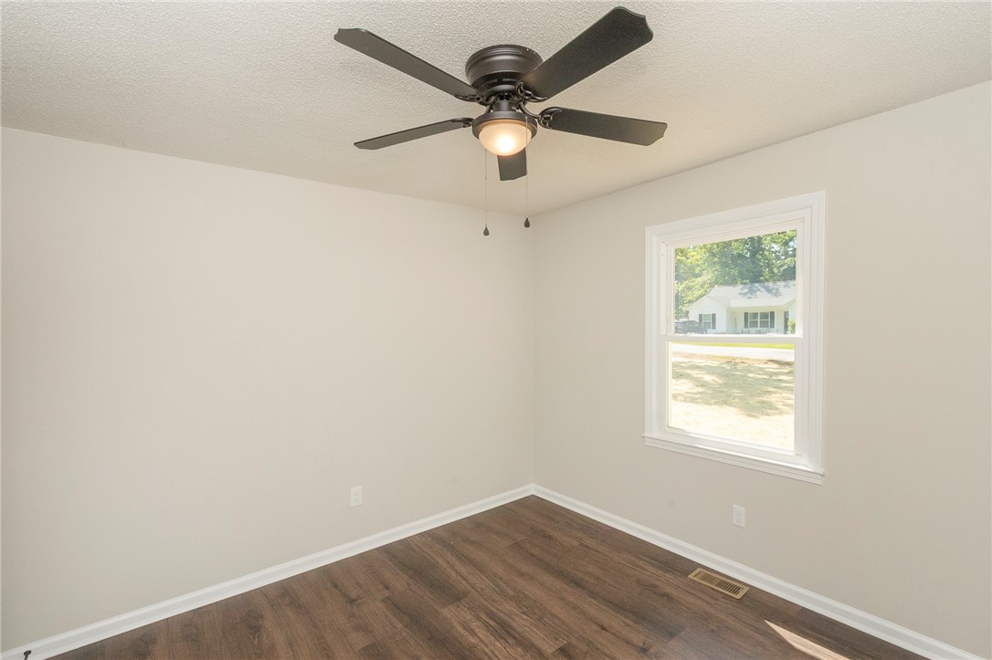 113 Linda Lane Honea Path, SC 29654 - Photo 20 of 36 This bright room features a ceiling fan and rich wood flooring, offering comfort and style.