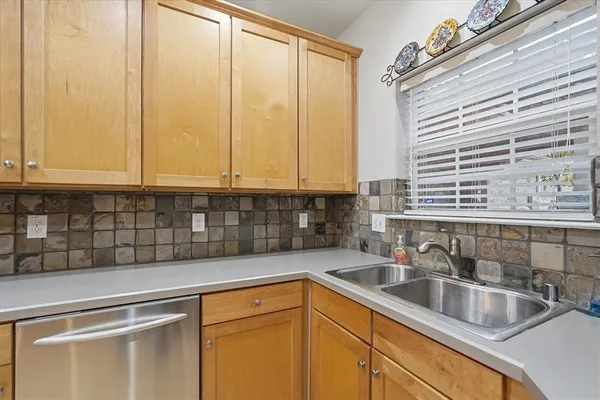 a kitchen with stainless steel appliances white cabinets a sink and a window