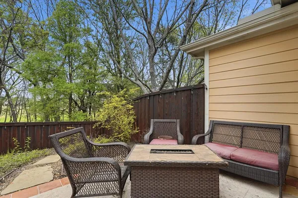 a view of a patio with a couch chairs and wooden fence