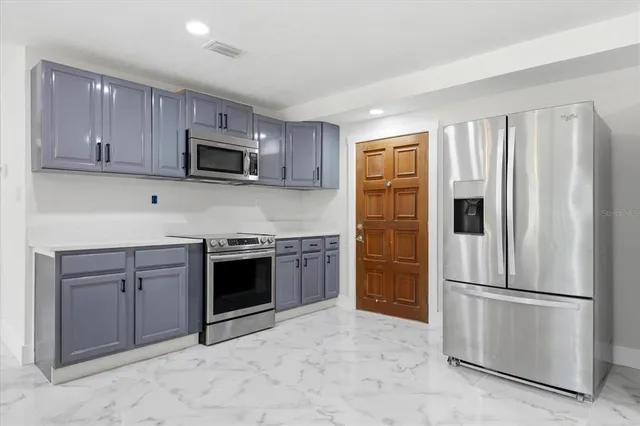 a kitchen with stainless steel appliances granite countertop a stove microwave and sink