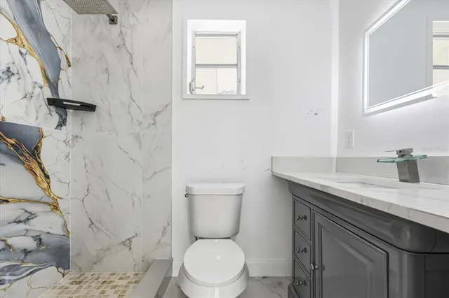 a bathroom with a toilet sink and mirror