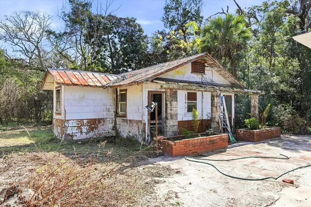 a view of a house with backyard and trees