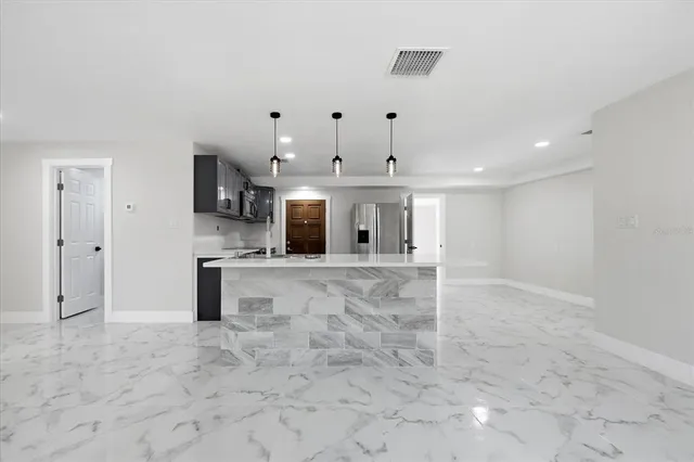 a large kitchen with stainless steel appliances granite countertop a stove a sink and a microwave