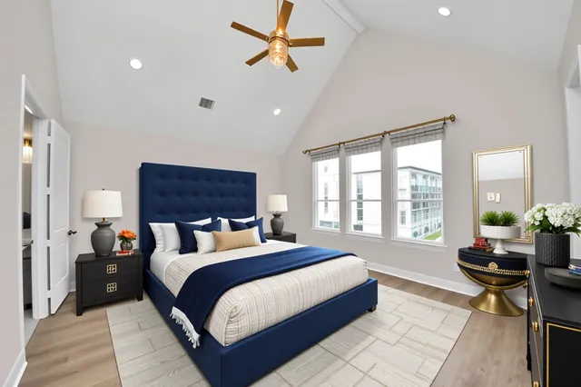 a bedroom with a bed a table and a potted plant