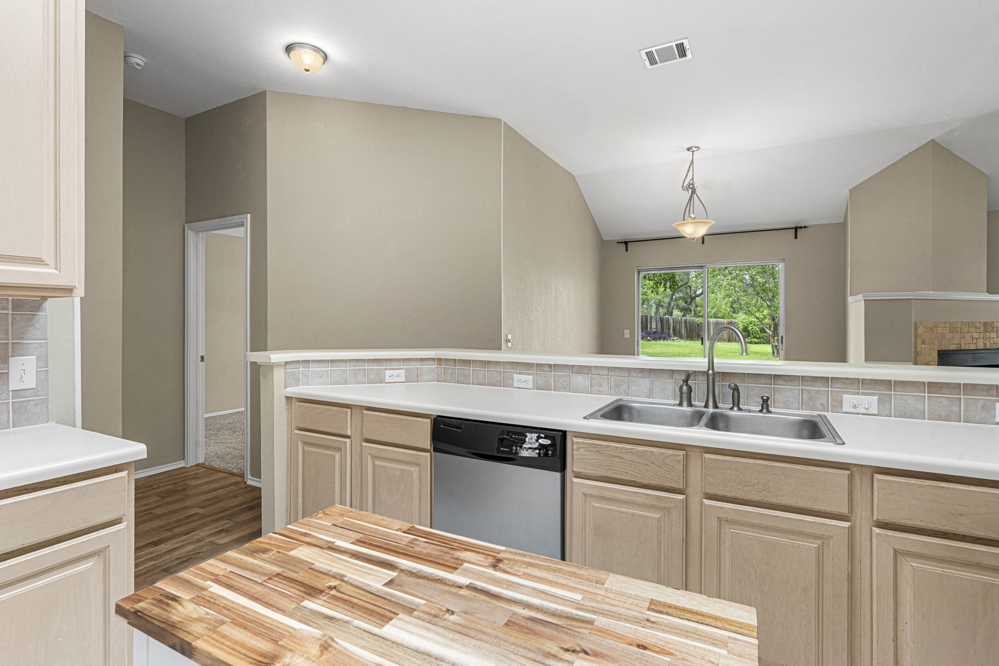 7172 Ridge Oak Road Austin, TX 78749 - Photo 22 of 40 A functional kitchen provides ample counter space, a double basin sink, and a clear view to the rear yard.